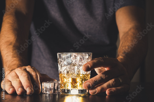 Obraz na płótnie dark background whiskey ice glass ice hand photo moody pouring alcohol bourbon bartender bar hotel home w salonie