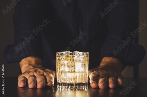 Obraz na płótnie dark background whiskey ice glass ice hand photo moody pouring alcohol bourbon bartender bar hotel home w salonie