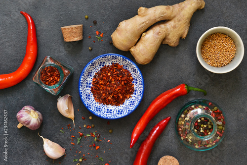 Asian spices: chili pepper, garlic, ginger, turmeric on a black background. Top view. photo