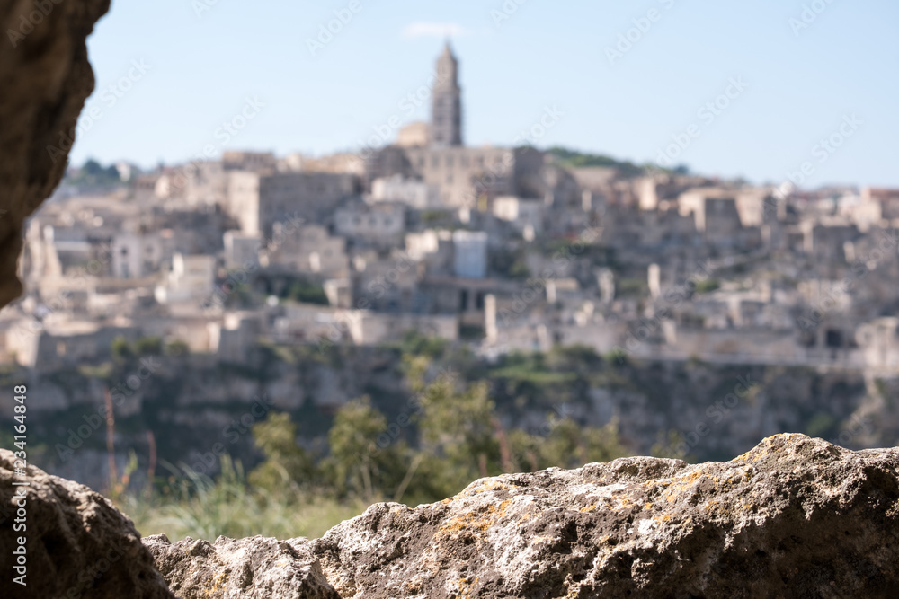 Obraz premium Houses built into the rock in the cave city of Matera, Basilicata Italy. Matera has been designated European Capital of Culture for 2019. Photographed from inside a cave in the ravine opposite.