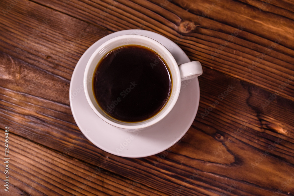 Cup of dark coffee on wooden table. Top view Cup of dark coffee on wooden table. Top view