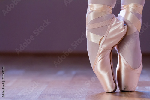 Feet dressing a pair of pointe shoes