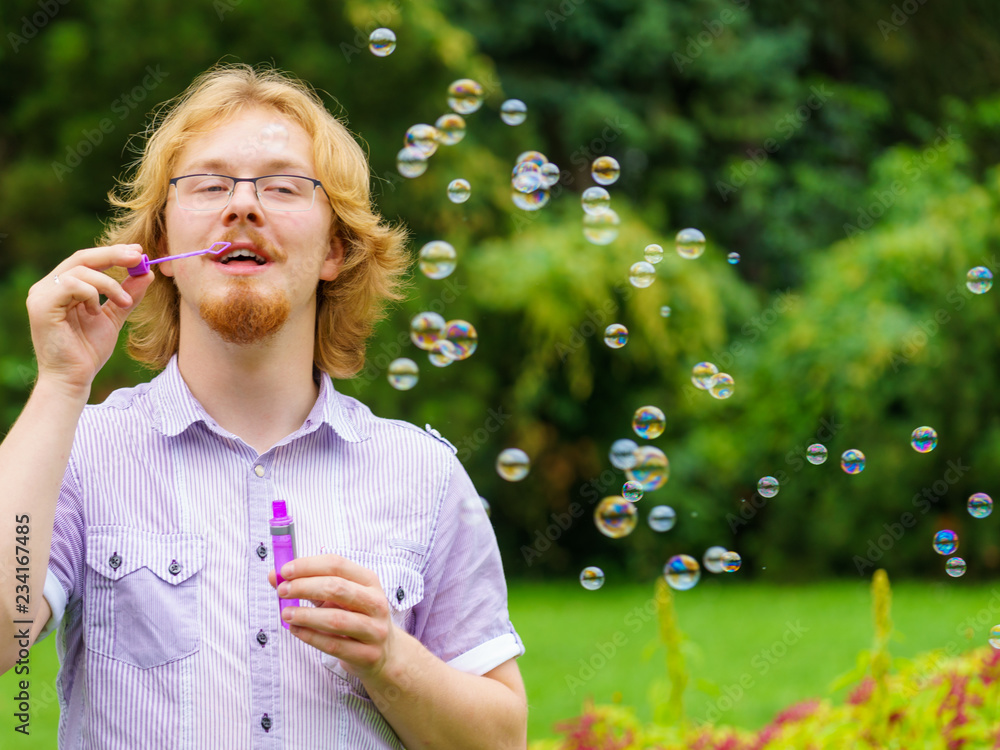 Man blowing soap bubbles, having fun