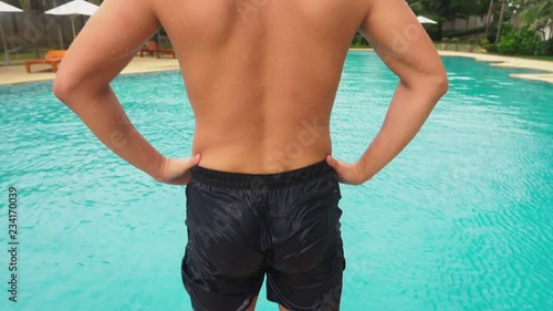 someone pushed the young man into the pool, he ridiculously falls and makes a funny face. super slow motion