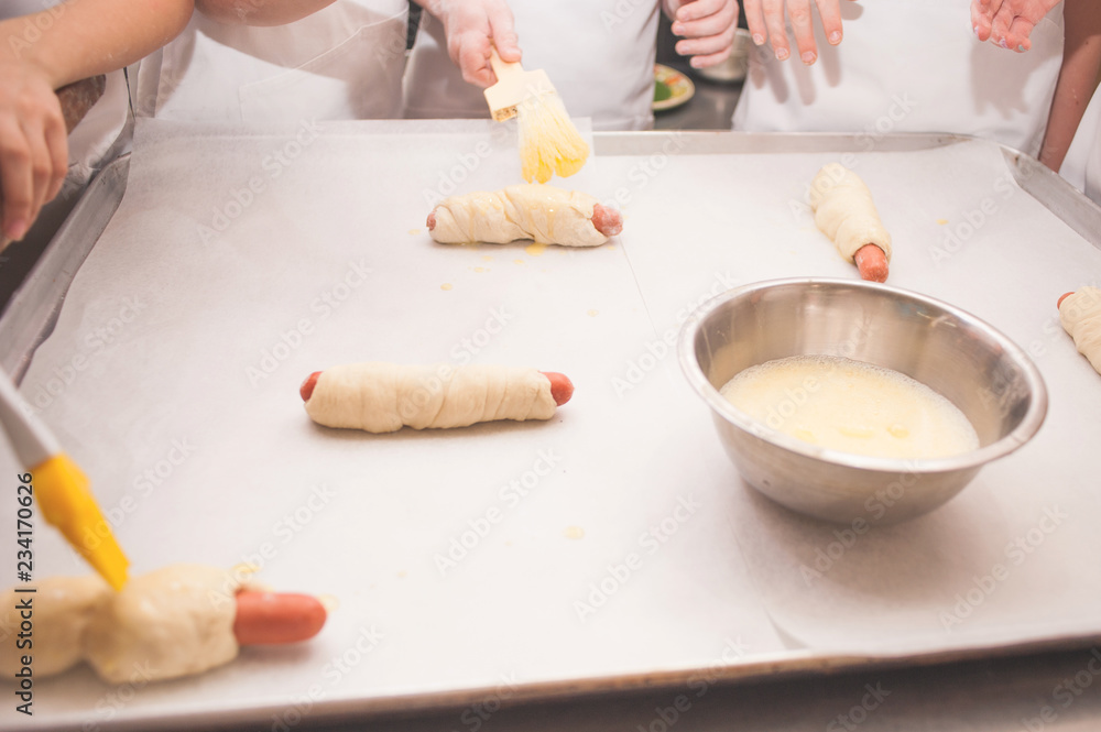 Fototapeta premium Young children make sausage dough. Hands closeup