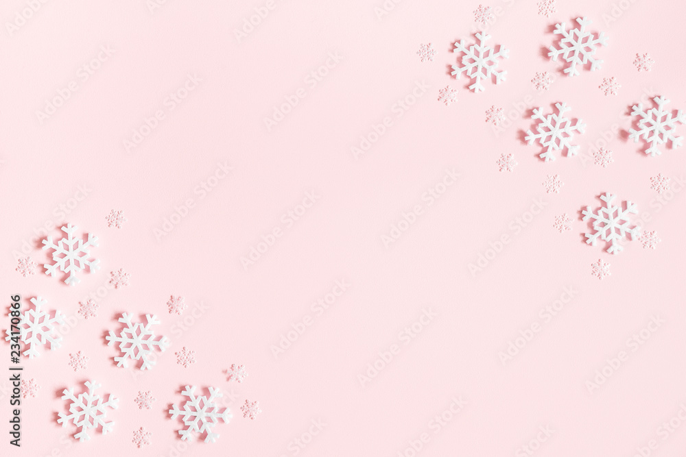 Christmas or winter composition. Frame made of snowflakes on pastel pink background. Christmas, winter, new year concept. Flat lay, top view, copy space