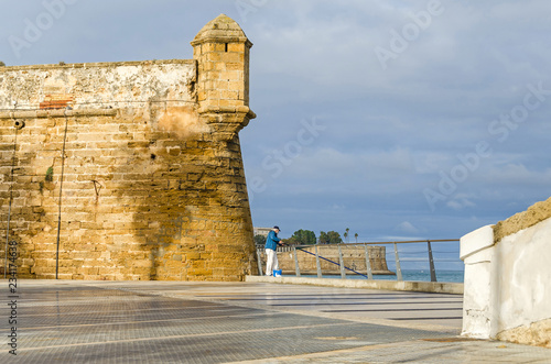 Plaza de Filipinas with a man fishing in the Bay of Cadiz, Spain photo