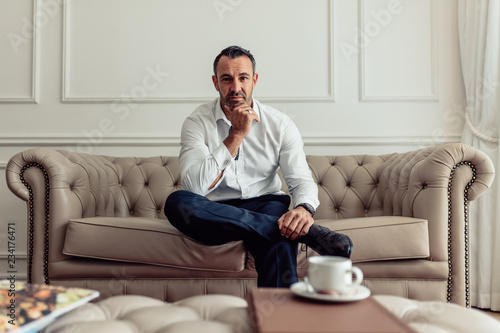 Confident businessman relaxing in hotel room