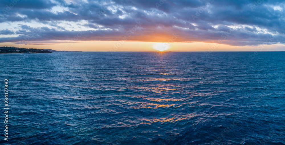 Obraz premium Breathtaking sunset over calm sea panorama