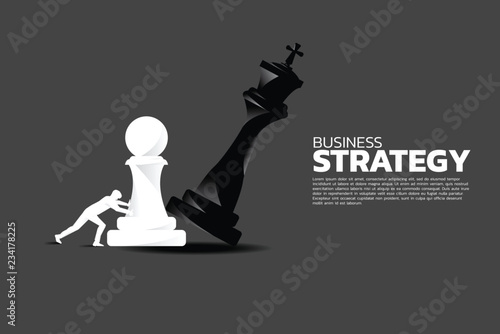 Silhouette of businessman push pawn chess piece to checkmate the king.