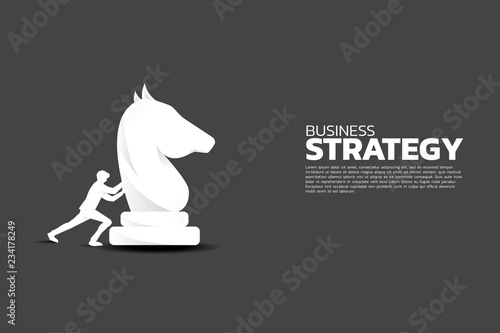 Silhouette of businessman push knight chess piece.