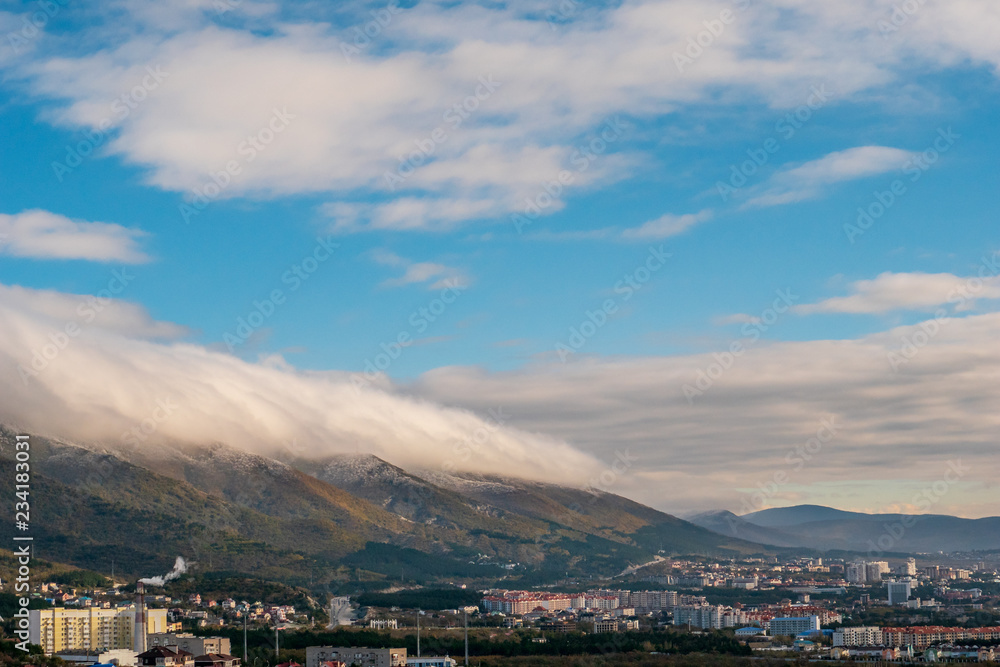 Gelendzhik mountains panorama with low lying clouds before wind and city buildings