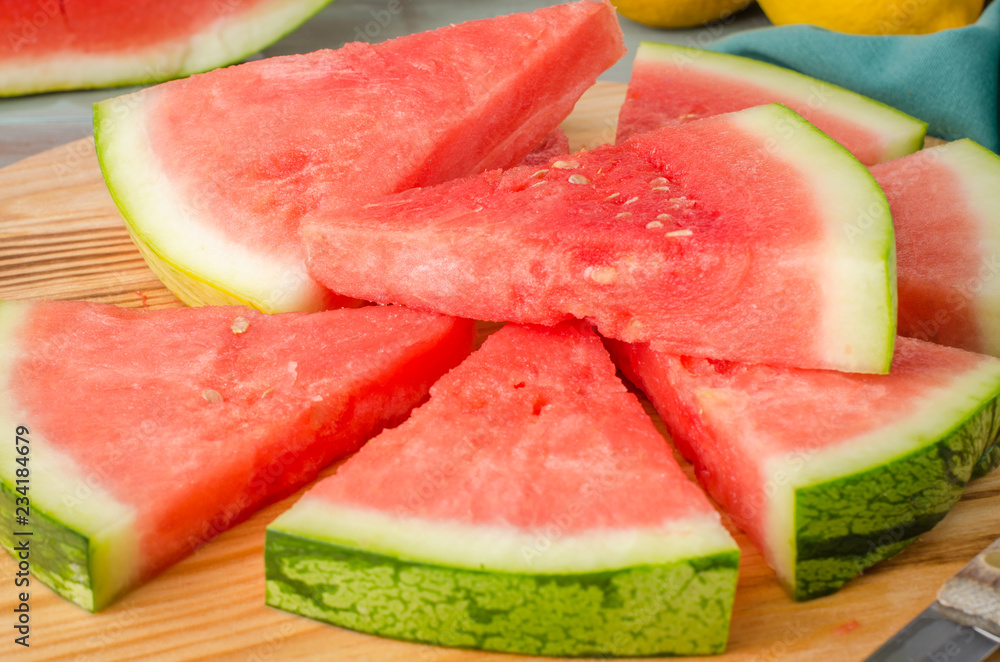 Slices of watermelon on a wood cutting board Slices of watermelon on a wood cutting board