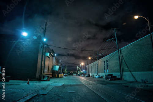 Industrial urban street city night scene with vintage factory warehouses and train tracks photo