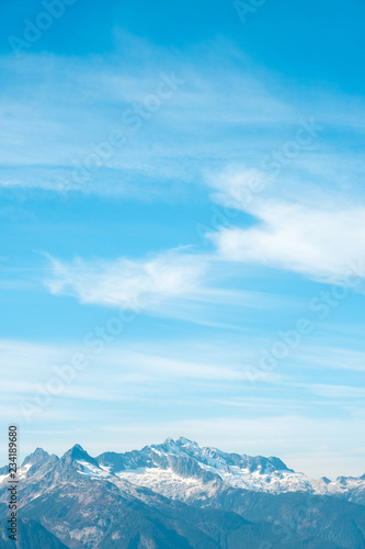 Large alpine peak and blue cloudy sky