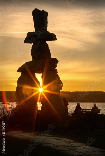 Vancouver Inukshuk Sunset. People out for a walk at sunset at English Bay, Vancouver.