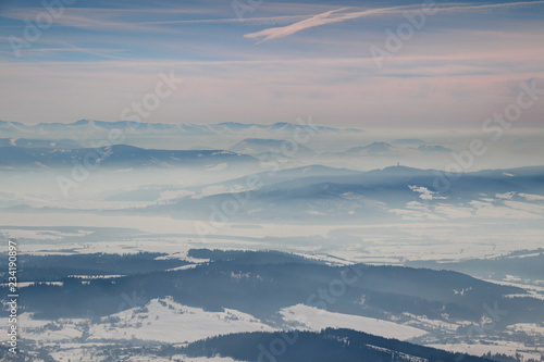 Frozen winter scenery with blue mountain ridges in the distance and snowy valleys filled with fog in Orava and Liptov regions, Oravska Magura Chocske vrchy Nizke Tatry ranges Slovakia Eastern Europe © nogreenabove2k