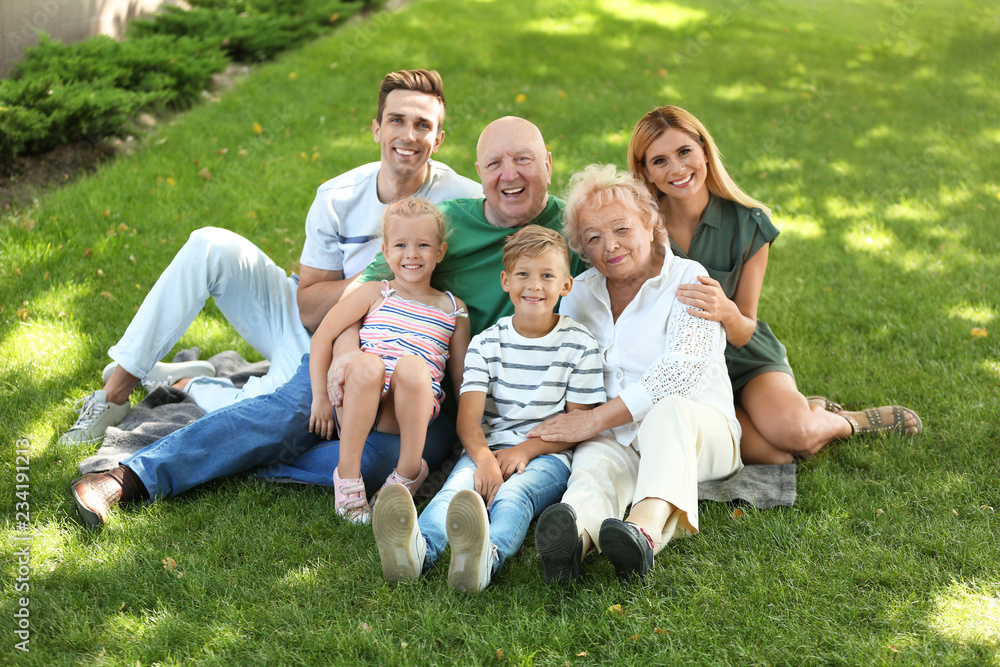 Couple with children and elderly parents in park Couple with children and elderly parents in park