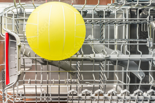Childrens yellow ball lies in the dishwasher