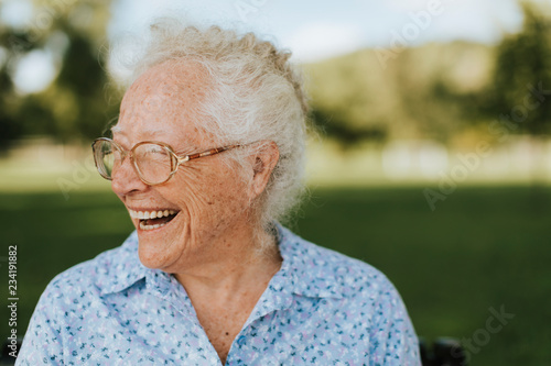 Cheerful senior woman sitting in the park