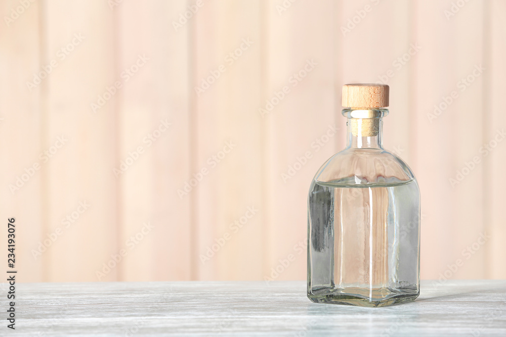 Glass bottle with vinegar on wooden table. Space for text