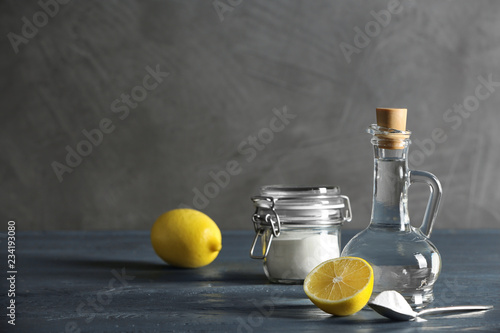 Composition with vinegar, lemon and baking soda on table. Space for text