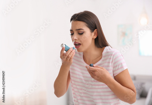 Tableau sur toile Woman with asthma inhaler in light room