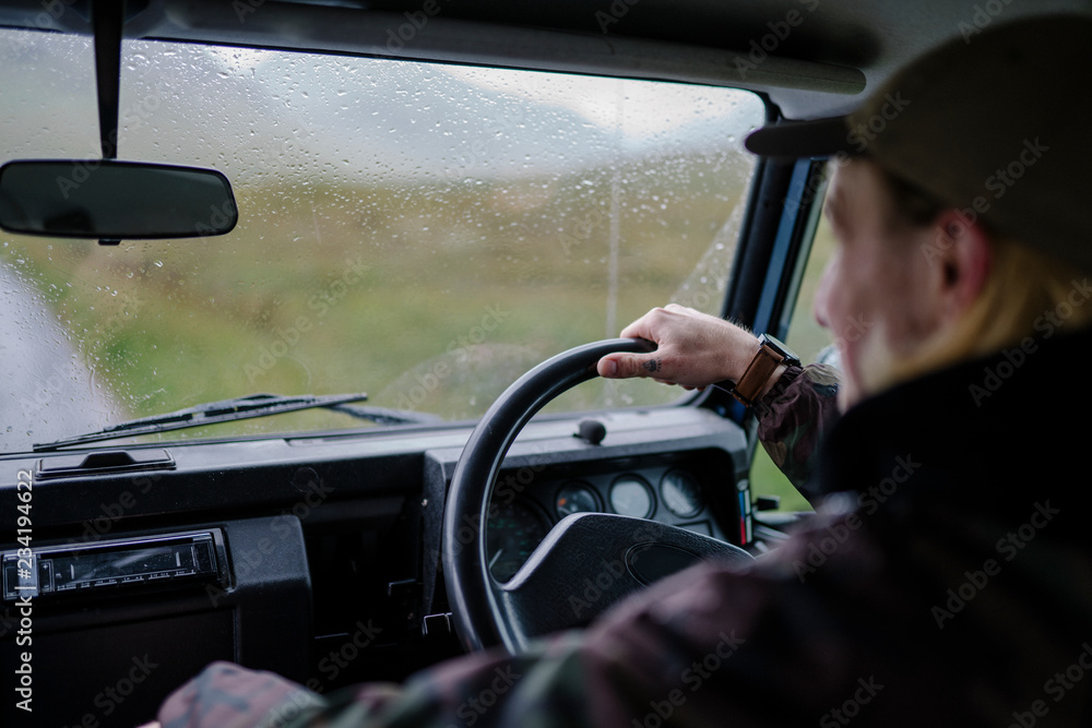 Man driving an old SUV in the Highlands Man driving an old SUV in the Highlands