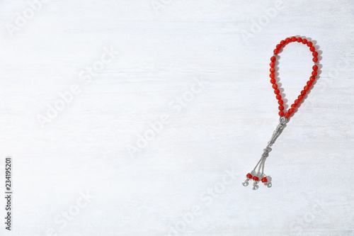 Muslim prayer beads and space for text on white background, top view