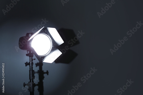 Professional photo studio lighting equipment on dark background. Space for text