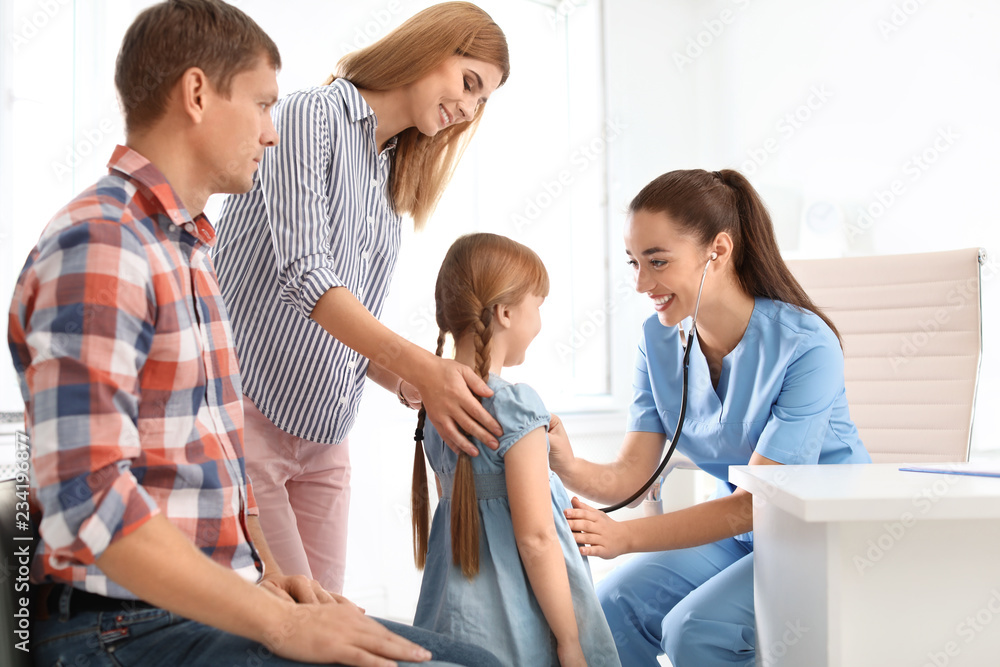 Obraz premium Children's doctor examining little girl near parents in hospital