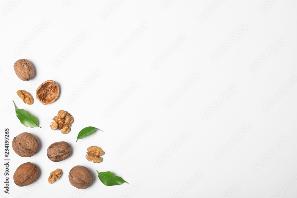 Walnuts with leaves on white background, flat lay with space for text Walnuts with leaves on white background, flat lay with space for text
