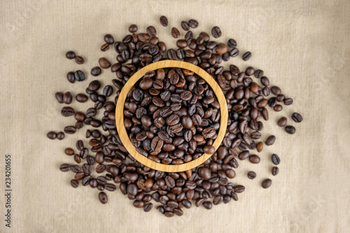 coffee beans on wooden bowl isolated top viwe on sackcloth background.