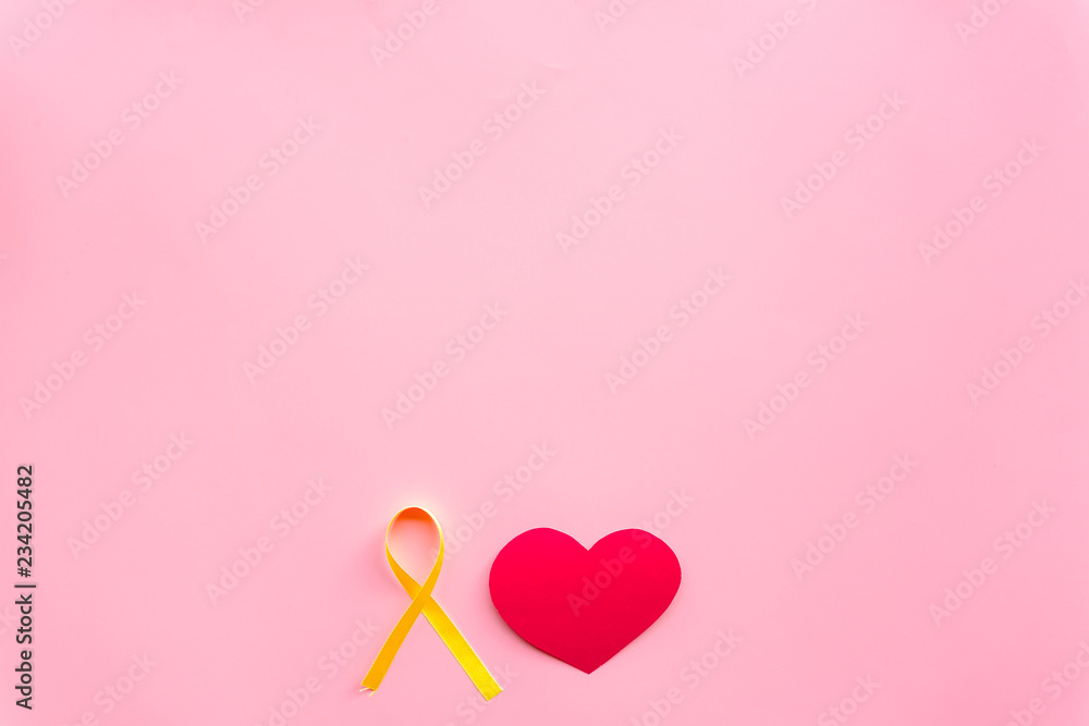 Endometriosis. Gynecological diseases concept. Symbolic yellow ribbon near heart sign on pink background top view space for text