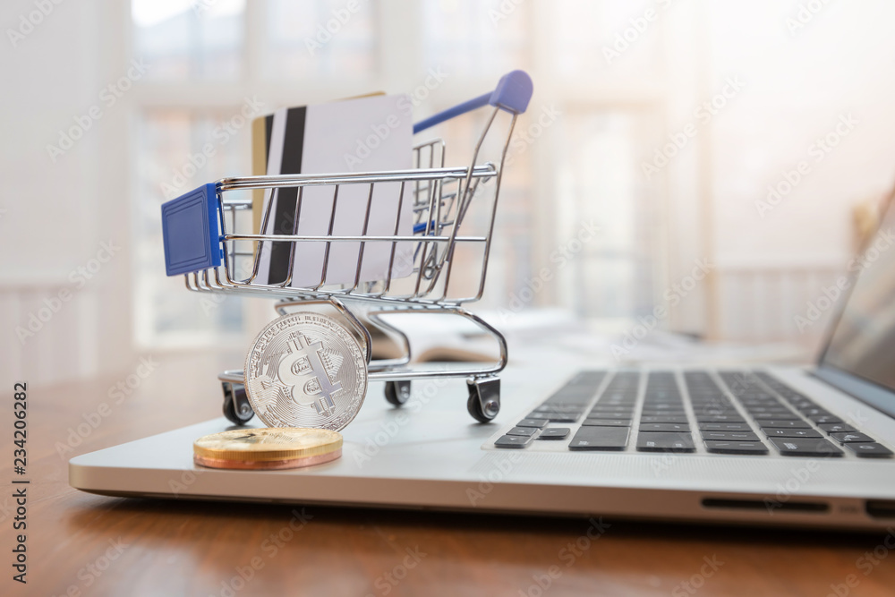 Business and finance concept,  Close up shopping cart with credit card and bitcoin on desk for E-Commerce online shopping.