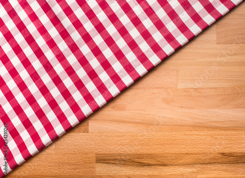 Red checkered fabric on wood table background.For decoration key visual l