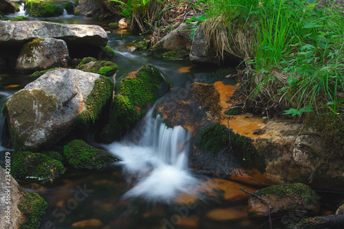 A creek with clear water in a mountainous area closeup.