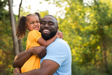 Father laughing and playing with his daugher.