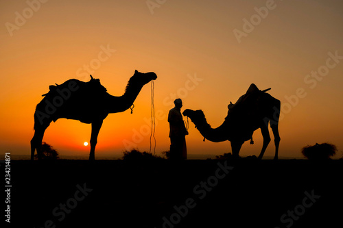 Silhouette of camel trader crossing the Thar Desert in Jaisalmer  India.