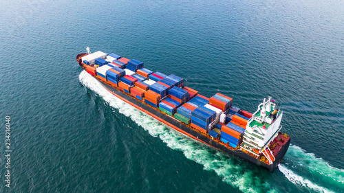 Aerial view cargo container ship sailing, container cargo ship in import export and business logistic and transportation of international by container ship in the open sea.
