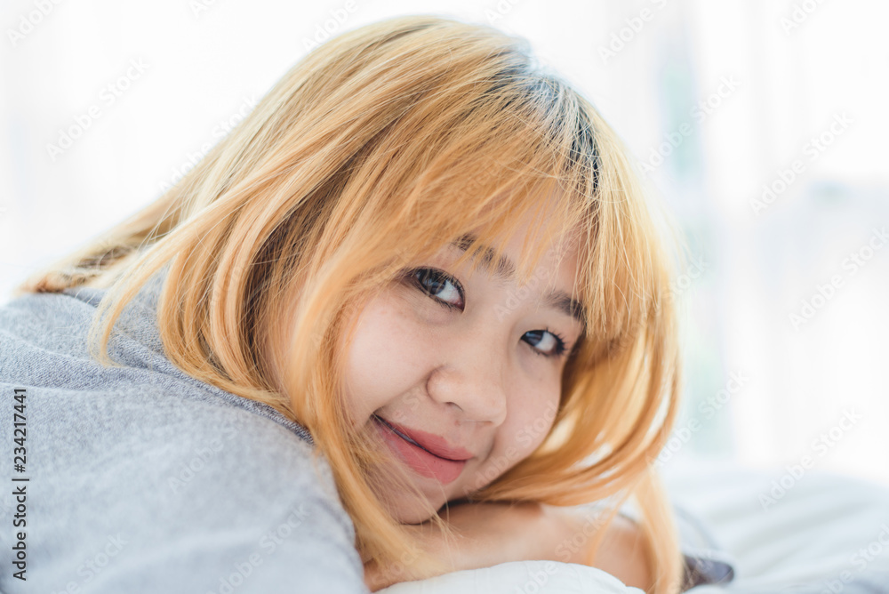 Portrait beautiful young Asian woman on bed at home in the morning. Cheerful Asian woman wearing a comfortable sweater and smiling on her bed. Relaxing room. lifestyle asia woman at home concept. Portrait beautiful young Asian woman on bed at home in the morning. Cheerful Asian woman wearing a comfortable sweater and smiling on her bed. Relaxing room. lifestyle asia woman at home concept.