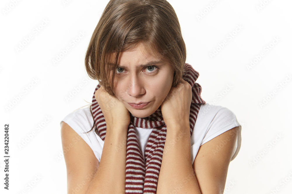 Disease, health condition, sickness and illness concept. Close up image of sad girl with sore throat posing in studio. Depressed young woman with painful expression, having influenza symptoms Disease, health condition, sickness and illness concept. Close up image of sad girl with sore throat posing in studio. Depressed young woman with painful expression, having influenza symptoms