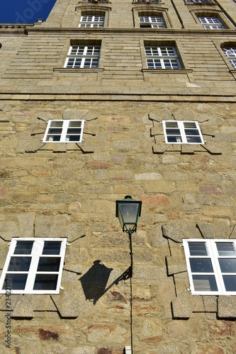 Old iron street light in stone wall with white windows. Town Hall, Pazo de Raxoi. Santiago de Compostela, Spain.  photo