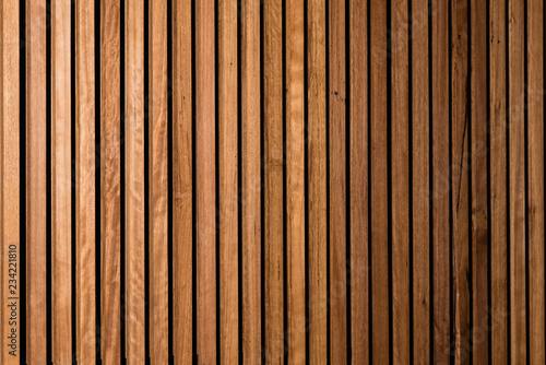 Background of interior vertical timber panelling with subtle fall off of light and focus to the right, suitable for backdrop for corporate portraits in business environment 