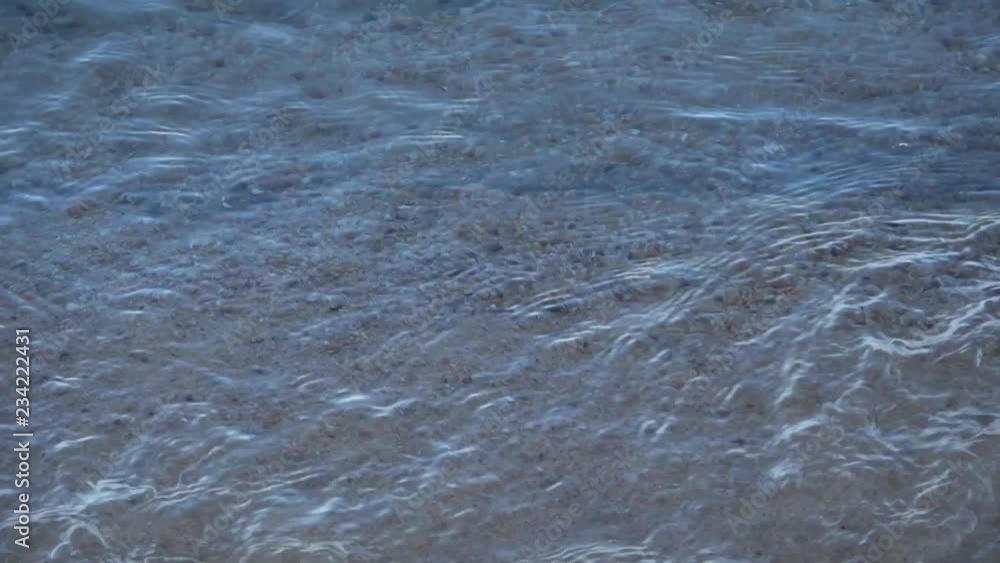 Slow motion small beach waves rolling in in very clear water Slow motion small beach waves rolling in in very clear water