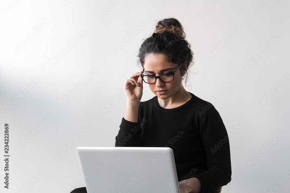 Beautiful woman with curly hair dressed on black working or shopping using computer or tablet Beautiful woman with curly hair dressed on black working or shopping using computer or tablet