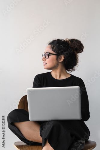 Beautiful woman with curly hair dressed on black working or shopping using computer or tablet