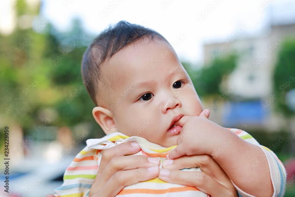 Close-up Infant baby boy is sucking finger with Asian mother carrying. Close-up Infant baby boy is sucking finger with Asian mother carrying.