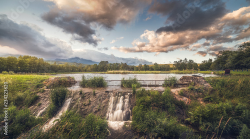 Strba Pond lit by Golden Light at Sunset with High Tatras Mountains in Background, Slovakia.