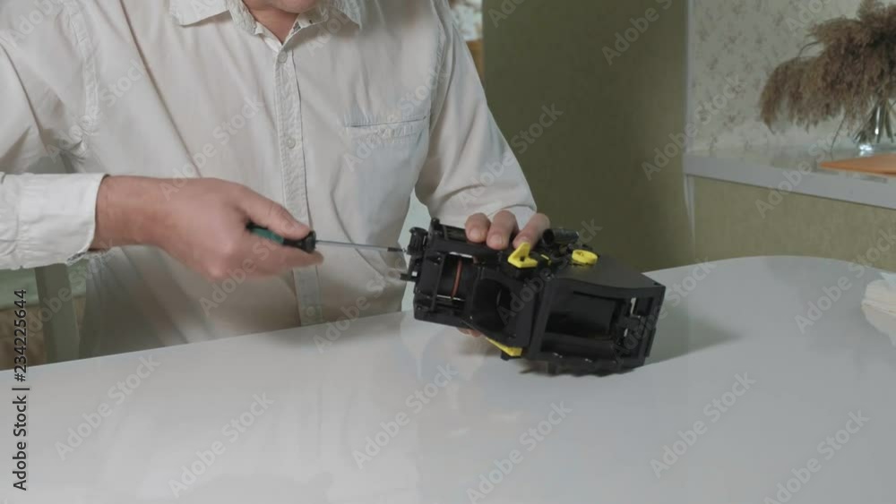 A man is repairing a coffee-making unit of a coffee machine, repair shop of coffee makers A man is repairing a coffee-making unit of a coffee machine, repair shop of coffee makers